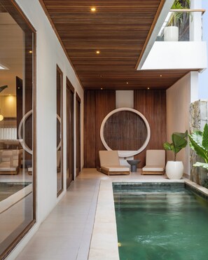 A modern outdoor pool area with lounge chairs, a small table, and a potted plant. - Villa Albizia - 2BR private pool villa near Canggu (Mengwi)