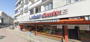 Un escaparate con un letrero que dice 'Gold Centro' y una exhibición de frutas y verduras frescas en el exterior.