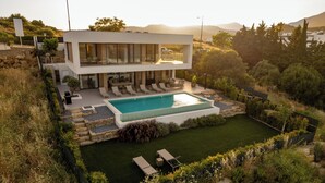 Une maison moderne à deux étages, dotée d’une piscine, d’un espace extérieur aménagé et d’un jardin bien entretenu.