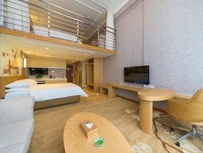 A modern hotel room with a bed, a desk, a TV, and a balcony.