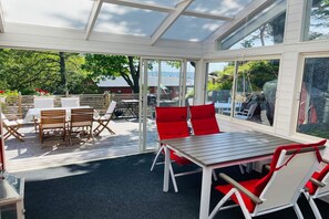 A covered outdoor area with a table and chairs, a wooden deck, and a view of the surrounding landscape. - 4 star holiday home in KARLSHAMN (KARLSHAMN)