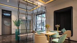 A modern interior with a central table, chairs, and a decorative vase. - XANA International Hotel Baiyun (Guangzhou)