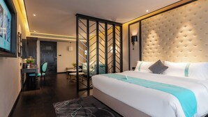 A modern hotel room with a large bed, a desk, a chair, and a decorative wall panel. - XANA International Hotel Baiyun (Guangzhou)