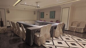 Ein Konferenzraum mit einem langen Tisch, Stühlen und einem gemusterten Boden.