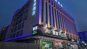 Ein Hotel mit moderner Fassade, mehreren Stockwerken und beleuchteter Beschilderung.