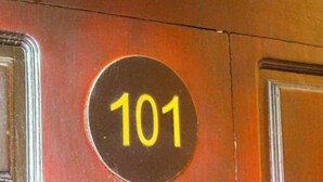A door with a circular sign displaying the number 101. - Heavens Gate Ella (Ella)