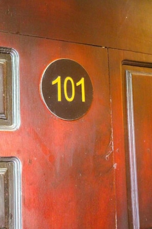 A door with a circular sign displaying the number 101. - Heavens Gate Ella (Ella)