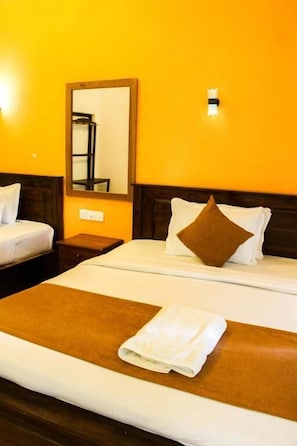 Ein Hotelzimmer mit Bett, Nachttisch, Spiegel und Wandleuchte.