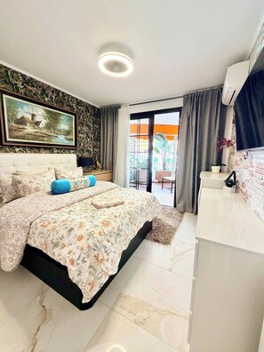 Een slaapkamer met een bed, een schilderij, een raam en een balkon.