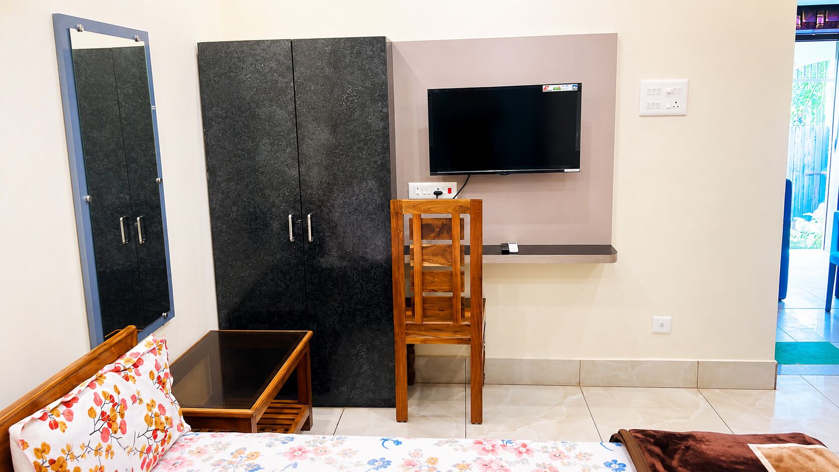 A room with a bed, a desk, a TV, and a wardrobe.