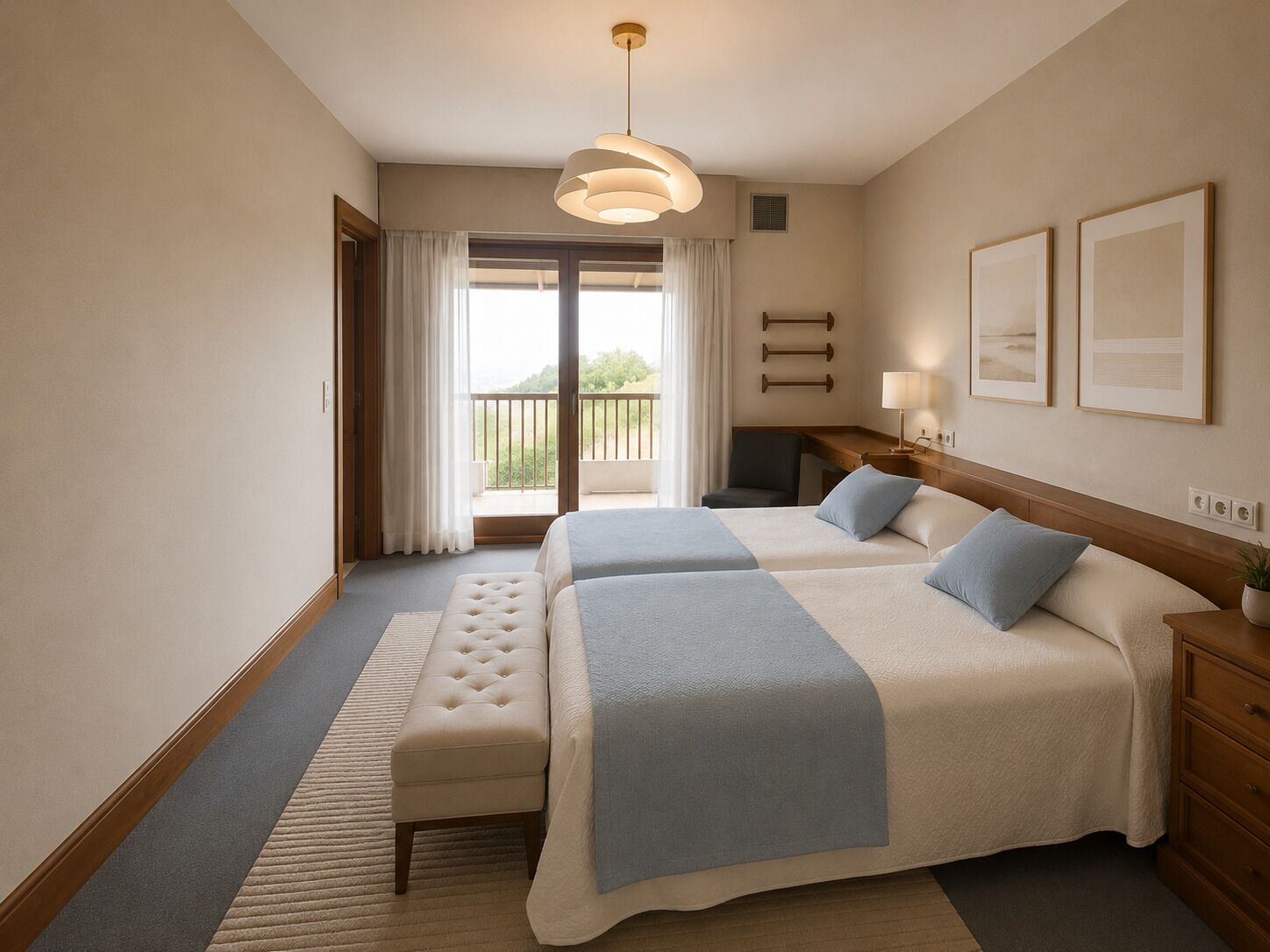 Quarto de hotel com duas camas, um banco, uma escrivaninha, uma cadeira, varanda e luminária suspensa.