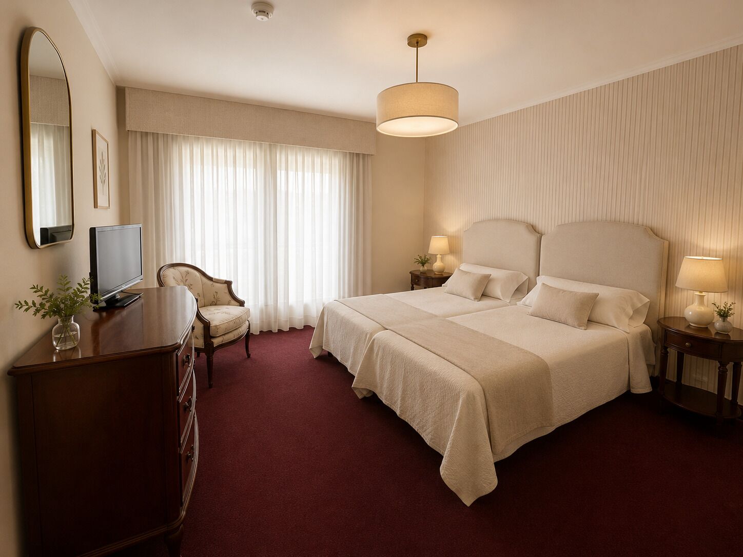 A hotel room with a large bed, a desk with a TV, a chair, and a lamp.