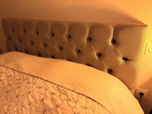 A bed with a tufted headboard and a floral-patterned bedspread. - Studio lease mobility near Paris (Aulnay-sous-Bois)