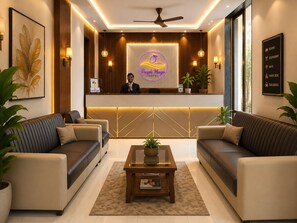 A hotel reception area with a reception desk, two sofas, a coffee table, and a reception sign.