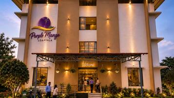 A hotel named Purple Mango with a modern facade, a welcoming entrance, and a signboard above the entrance.