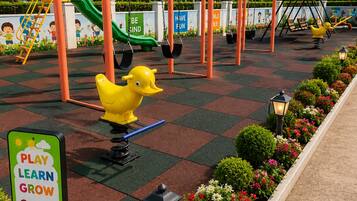 A playground with swings, slides, and a duck-shaped seesaw.
