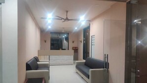Una sala de estar moderna con un sofá, una mesa de centro y una pared divisoria de cristal.