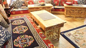 Una habitación tradicional con un conjunto de sofás, una mesa de madera y alfombras estampadas.