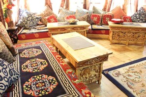 Una habitación tradicional con un conjunto de sofás, una mesa de madera y alfombras estampadas.