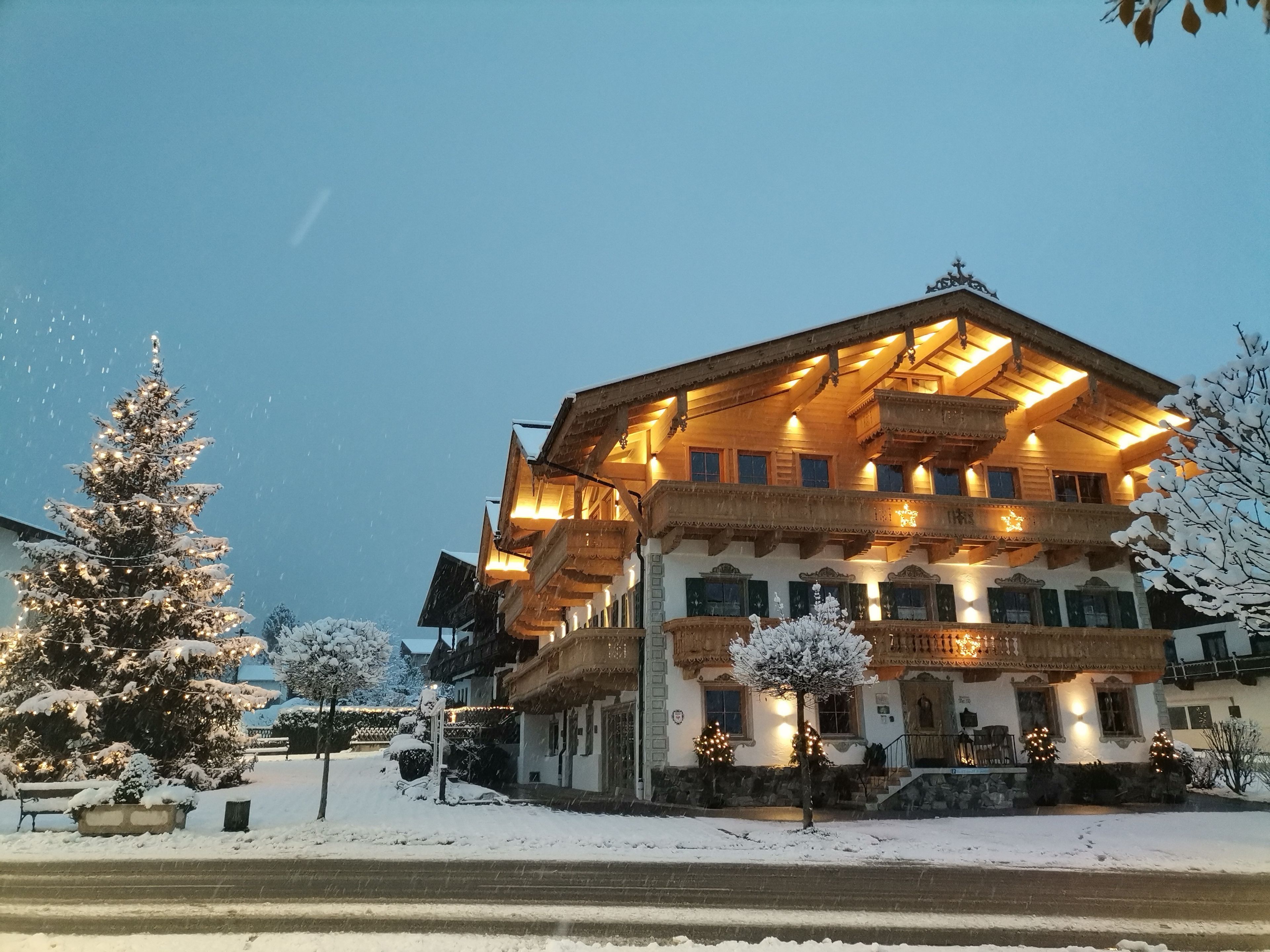 A multi-story building with a traditional wooden facade, balconies, and a snow-covered landscape.