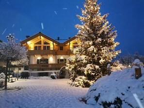 Schneebedeckte Landschaft mit einem großen Gebäude, das einen markanten Eingang und viele Fenster hat.