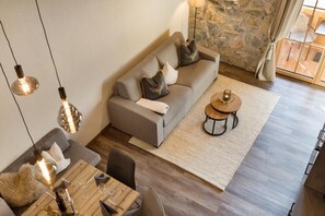 A modern living room with a sofa, coffee table, and dining area. - Apartment "Das Krumerhaus – Die Krumerlodge" with Mountain View, Balcony and Wi-Fi (Aschau im Zillertal)