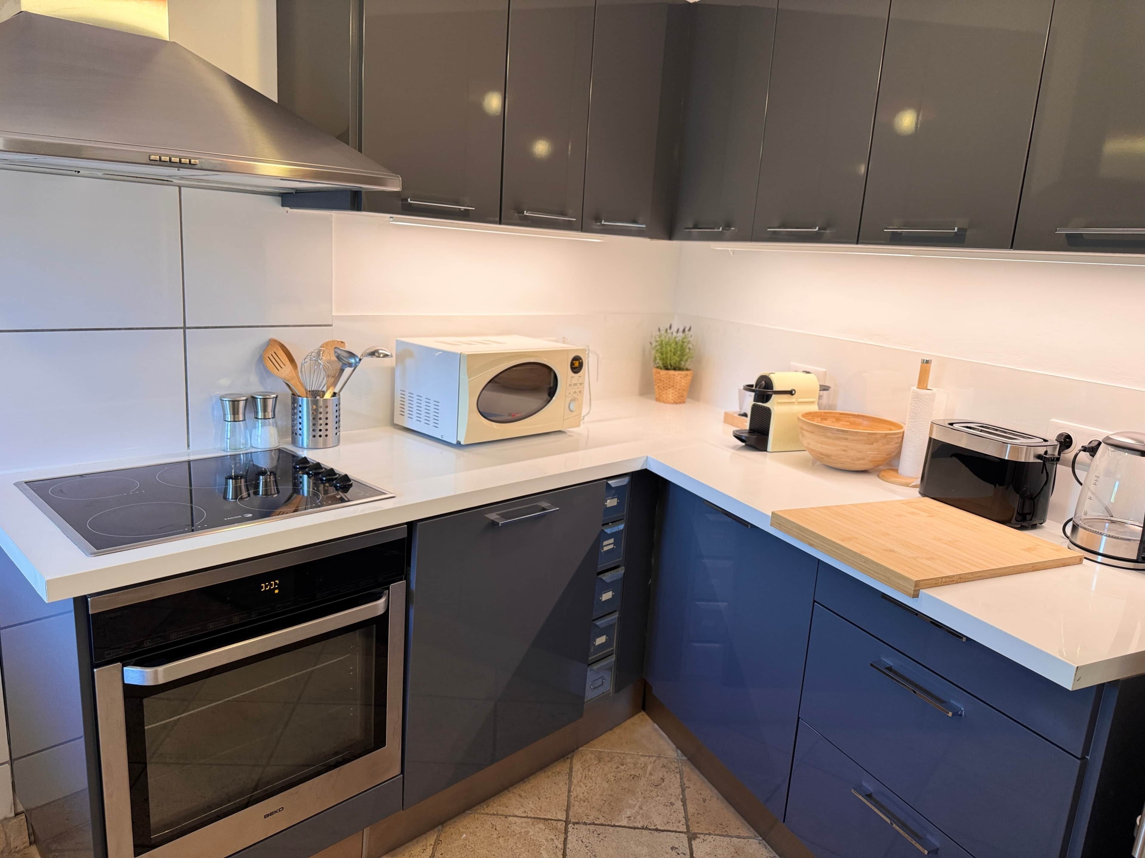 Eine moderne Küche mit integriertem Mikrowellenherd, Toaster und Kaffeemaschine.