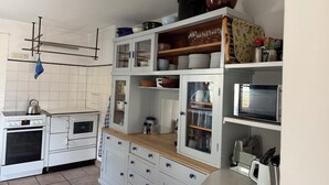 A kitchen with white cabinets, a stove, and a microwave. - Nusshof Vacation Home for up to 9 people (Berchtesgaden)
