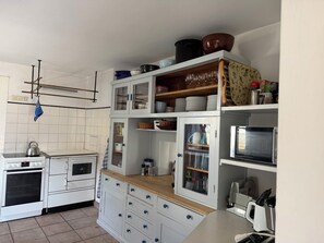 A kitchen with white cabinets, a stove, and a microwave. - Nusshof Vacation Home for up to 9 people (Berchtesgaden)