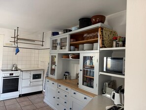 A kitchen with white cabinets, a stove, and a microwave. - Nusshof Vacation Home for up to 9 people (Berchtesgaden)