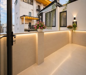 Een modern gebouw met balkon, plant in pot en een lamp.
