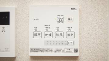 Un panneau de commande de thermostat doté de plusieurs réglages et d’un code QR.