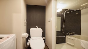 A bathroom with a toilet, a shower, and a sink. - New Normal Hotel in ASAHIBASHIEKI (Naha City)