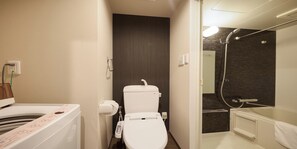 A bathroom with a toilet, a shower, and a sink. - New Normal Hotel in ASAHIBASHIEKI (Naha City)