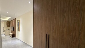 Un corridoio moderno di un hotel con un'armadiatura in legno, un angolo cottura e uno specchio.