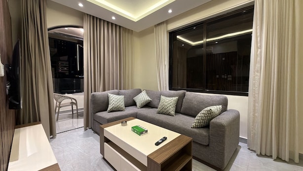 Ein modernes Wohnzimmer mit einer Couch, einem Couchtisch und einem Fernseher.