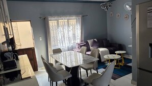 Ein modernes Wohnzimmer mit Essbereich, Sofa und Küche.