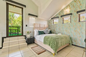 Ein Schlafzimmer mit Bett, Nachttisch, Fenster mit Jalousien, einer Tür zum Balkon und einer Wand mit Muster.