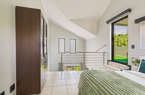 A bedroom with a bed, a window, a door, and a staircase. - Zalari Luxe Loft B, Nature 1-Bed Loft, Paulshof (Sandton)