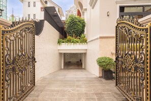 A gated entrance with a marble floor, a small potted plant, and a staircase leading to a building. - Garden Oasis Pool Villa with 10 Bedrooms (Ho Chi Minh City)