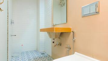 A bathroom with a white sink, a mirror, and a shower.