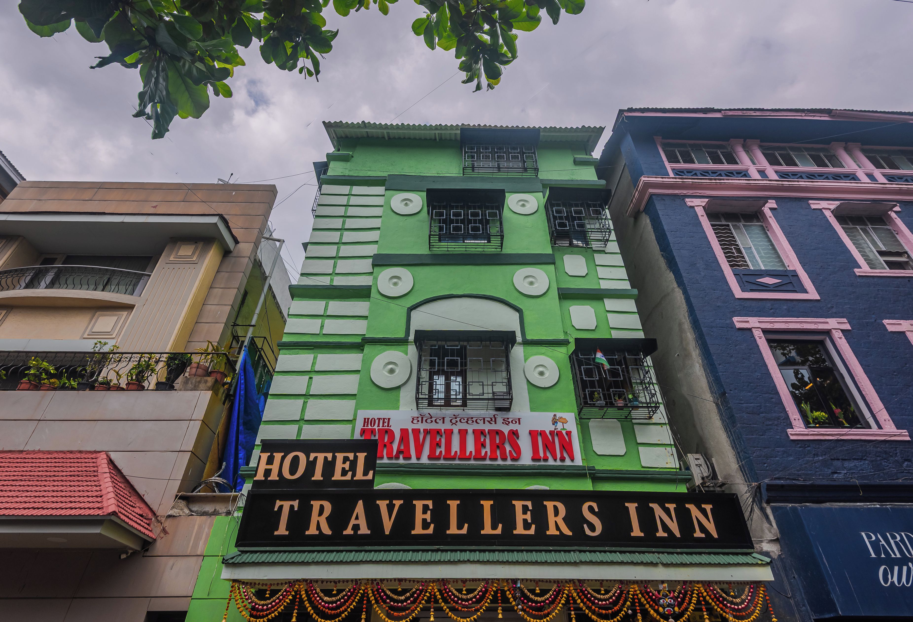 Un edificio de varios pisos con un letrero que indica 'Hotel Travellers Inn', mostrando que se trata de un hotel.