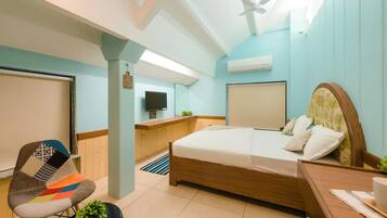 Una habitación de hotel moderna con una cama, un escritorio, una silla y un televisor.
