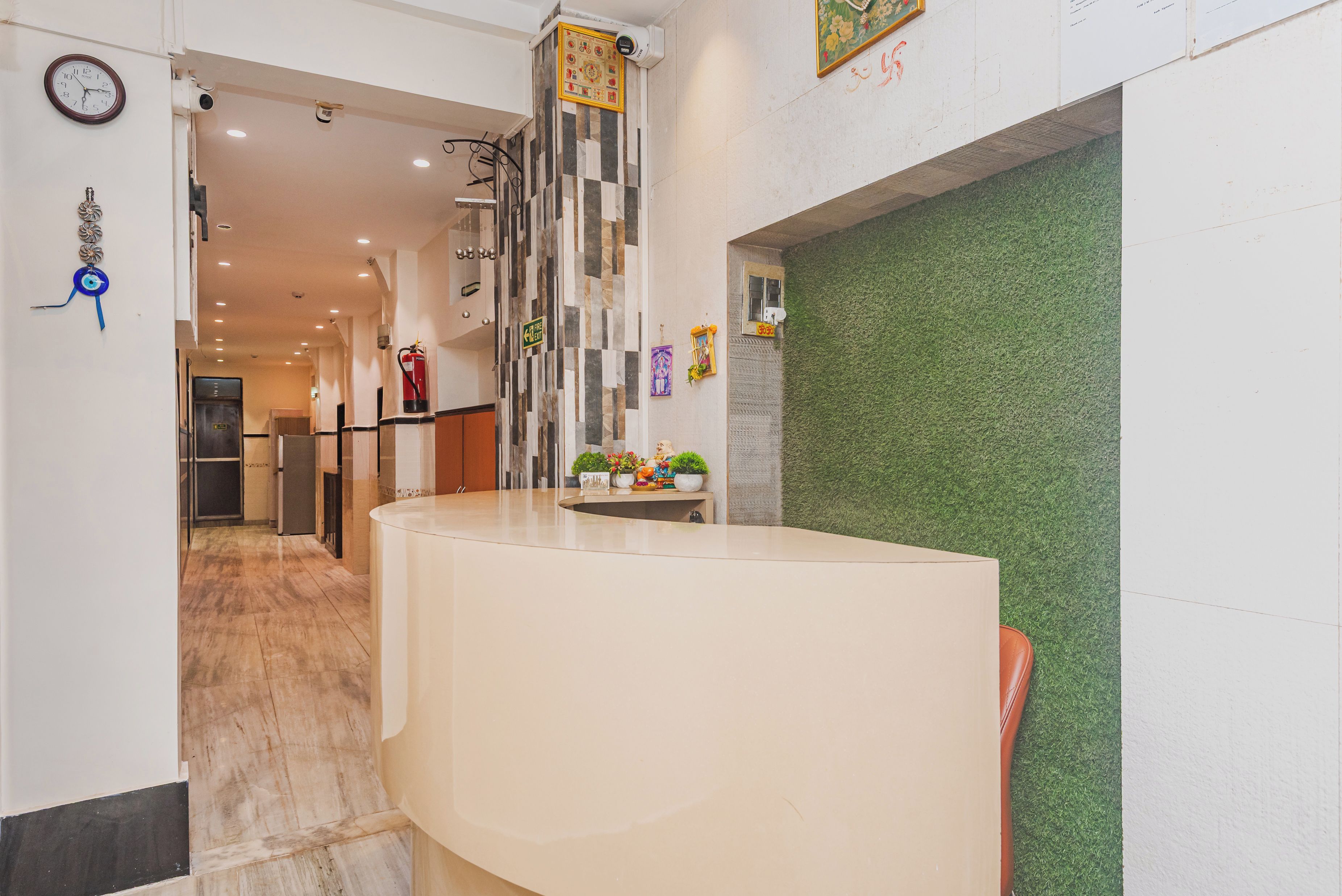 A reception area with a curved reception desk, a clock, and a fire extinguisher mounted on the wall.