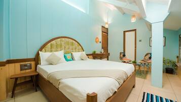 A bedroom with a large bed, bedside table, and a chair.