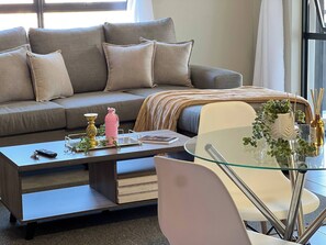 Ein modernes Wohnzimmer mit einer Couch, einem Couchtisch und einem Glastisch.