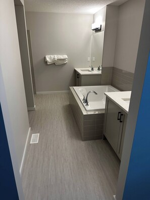 A modern bathroom with a bathtub, a sink, and a mirror.