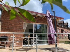 A brick house with a sliding glass door, a patio with a grill, and a purple umbrella. - La Clérynette awaits you in the heart of Château de Gaillard (Les Andelys)