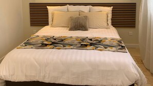 A bedroom with a bed, headboard, bedside lamps, and a window with curtains. - La Clérynette awaits you in the heart of Château de Gaillard (Les Andelys)