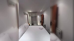 A hotel room with a large bed, a walk-in closet, and a door leading to a bathroom. - Bright 2 BDR APT on Charlotte Quay Dublin (Dublin)